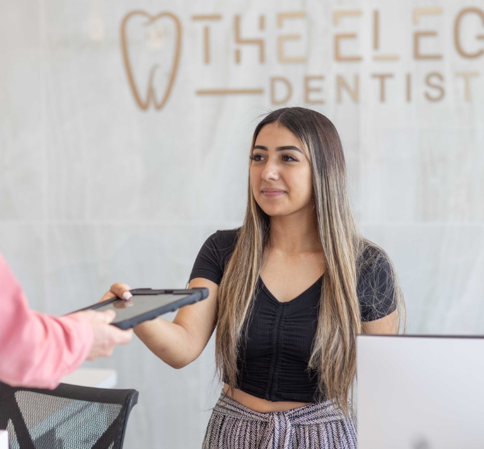 Dental team member explaining the cost of dental emergencies